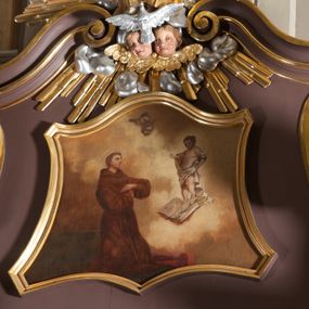 Zdjęcie nr 1: Obraz w kształcie zbliżonym do trapezu o krawędziach bocznych lekko wklęsłych, a dolnej i górnej wklęsło-wypukłej. Obraz przedstawia wizję św. Antoniego. Święty usytuowany nieco na lewo od osi kompozycji, zwrócony w trzech czwartych w lewo, klęczy na ziemi, ręce  założone ma przed sobą na wysokości klatki piersiowej i patrzy na ukazujące mu się Dzieciątko. Antoni ma małą głowę z dużymi oczami, nosem i cofniętym podbródkiem. Krótkie, brązowe włosy przysłaniają ucho, na brodzie krótki zarost. Ubrany w brązowy, obszerny habit z kapturem, łamiący się w grube fałdy. Przed nim, po prawej stronie obrazu u góry Dzieciątko. Chrystus unosi się ponad otwartą księgą i złożonym na niej kwiatem lilii. Prawą nogę wyciąga do przodu, lewą, zgiętą w kolanie ma cofniętą, prawą rękę wyciąga w stronę św. Antoniego w geście błogosławieństwa, lewą podtrzymuje białą tkaninę, która przechodzi przez obie ręce, zasłania przód ciała i regularnymi fałdami opada wzdłuż lewej nogi. Tło wypełniają jasnożółte obłoki na tle ciemniejszego nieba, u góry dwie główki anielskie. Obraz w złoconej, profilowanej ramie.