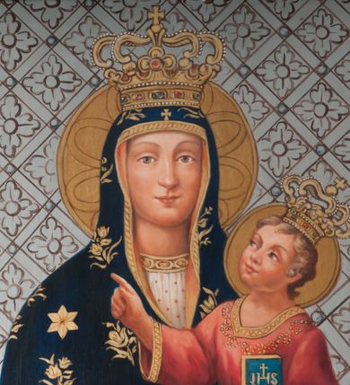 Zdjęcie nr 3: Matka Boska przedstawiona w półpostaci, ustawiona frontalnie, trzyma Dzieciątko na lewym ramieniu. Patrzy na widza, ma pogodny wyraz twarzy, jasnobrązowe oczy, prosty nos i małe usta. Dłonie składa razem, w lewej trzyma białą chustkę, w prawej ma wyprostowane dwa palce. Jest ubrana w białą suknię z pasem haftu pod szyją i granatowy maforion zdobiony kwietnymi gałązkami, lamowany złotem. Na maforionie nad czołem złoty krzyż grecki, na prawym ramieniu złota gwiazda. Dzieciątko patrzy na Matkę, prawą dłonią z wysuniętym palcem wyciąga przed siebie, w lewej trzyma książeczkę z chrystogramem na okładce. Jest ubrane w czerwoną sukienkę zdobioną haftem i lamowaną złotem, na nogach ma sandały. Na głowach obu postaci zamknięte, złote korony inkrustowane kamieniami szlachetnymi, wokół nich nimby. Tło w formie srebrnej, skośnej kratki z rozetami. 