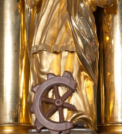 Zdjęcie nr 17: Nastawa ołtarzowa architektoniczna, jednokondygnacyjna, trójosiowa ze zwieńczeniem. 
Mensa w typie sarkofagowym, na niej rozbudowane, architektoniczne, dwukondygnacyjne, trójosiowe tabernakulum o wklęsło-wypukłej strukturze. Dolną kondygnację tabernakulum stanowi dwudzielny cokół przerwany w części środkowej na szafkę zamykaną drzwiczkami zdobionymi symbolami eucharystycznymi. Drugą kondygnację stanowi tron wystawienia – półkolista wnęka zdobiona motywem kiści winogron, z gołębicą Ducha Świętego na podniebieniu. Tron jest flankowany wnękami z dekoracją rocaille'ową oraz parami kolumn na tle pilastrów. Na dźwiganym przez kolumny rozbudowanym belkowaniu przeciwstawnie ustawione anioły kierują swój wzrok na krucyfiks. Zwieńczenie osi centralnej stanowi posążek baranka stojącego na księdze z siedmioma pieczęciami. 
Nastawa ołtarzowa jest oparta na wysokim, dwudzielnym cokole. Pole środkowe wypełnia nisza w kształcie stojącego prostokąta zamkniętego półkoliście z umieszczonym w niej obrazem Serca Pana Jezusa, powyżej którego znajduje się utworzony z motywów płomienistych rocaille'ów kartusz z koroną umieszczoną ponad dwoma skrzyżowanymi berłami. Pole centralne flankowane parami kolumn o rozbudowanych, kompozytowych kapitelach złożonych ze stylizowanych liści akantu i palmety pomiędzy wolutami, stojącymi na tle pilastrów połączonych fryzem palmetowym. Między nimi figury świętych: Katarzyny po lewej stronie i Barbary po prawej. Nastawa ujęta uszami z rocaille'u i spływów wolutowych. Kolumny dźwigają wyłamane na ich osiach belkowanie dekorowane kimationem i ząbkowaniem, z przyczółkiem przerwanym na rozbudowaną kompozycję Trójcy Świętej. W centrum przedstawienia siedzą Chrystus trzymający obiema rękami krzyż łaciński oraz Bóg Ojciec błogosławiący prawą i trzymający berło w lewej ręce. Między nimi drugi symbol władzy królewskiej – jabłko zwieńczone krzyżem, stanowiące również odniesiecie do globu ziemskiego. Postacie tronują wśród chmur, w których umieszczono główki aniołków. Powyżej nich gołębica Ducha Świętego w centrum glorii promienistej stanowiącej tło dla przedstawienia.  
 Struktura marmoryzowana na kolor zielony i niebieski; kolumny, detale, figury oraz tabernakulum złocone i srebrzone, polichromia figur w partiach ciała naturalistyczna.
