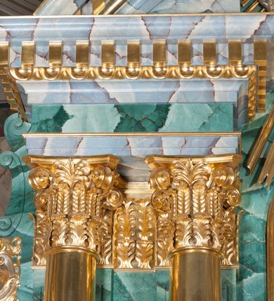 Zdjęcie nr 6: Nastawa ołtarzowa architektoniczna, jednokondygnacyjna, trójosiowa ze zwieńczeniem. 
Mensa w typie sarkofagowym, na niej rozbudowane, architektoniczne, dwukondygnacyjne, trójosiowe tabernakulum o wklęsło-wypukłej strukturze. Dolną kondygnację tabernakulum stanowi dwudzielny cokół przerwany w części środkowej na szafkę zamykaną drzwiczkami zdobionymi symbolami eucharystycznymi. Drugą kondygnację stanowi tron wystawienia – półkolista wnęka zdobiona motywem kiści winogron, z gołębicą Ducha Świętego na podniebieniu. Tron jest flankowany wnękami z dekoracją rocaille&#039;ową oraz parami kolumn na tle pilastrów. Na dźwiganym przez kolumny rozbudowanym belkowaniu przeciwstawnie ustawione anioły kierują swój wzrok na krucyfiks. Zwieńczenie osi centralnej stanowi posążek baranka stojącego na księdze z siedmioma pieczęciami. 
Nastawa ołtarzowa jest oparta na wysokim, dwudzielnym cokole. Pole środkowe wypełnia nisza w kształcie stojącego prostokąta zamkniętego półkoliście z umieszczonym w niej obrazem Serca Pana Jezusa, powyżej którego znajduje się utworzony z motywów płomienistych rocaille&#039;ów kartusz z koroną umieszczoną ponad dwoma skrzyżowanymi berłami. Pole centralne flankowane parami kolumn o rozbudowanych, kompozytowych kapitelach złożonych ze stylizowanych liści akantu i palmety pomiędzy wolutami, stojącymi na tle pilastrów połączonych fryzem palmetowym. Między nimi figury świętych: Katarzyny po lewej stronie i Barbary po prawej. Nastawa ujęta uszami z rocaille&#039;u i spływów wolutowych. Kolumny dźwigają wyłamane na ich osiach belkowanie dekorowane kimationem i ząbkowaniem, z przyczółkiem przerwanym na rozbudowaną kompozycję Trójcy Świętej. W centrum przedstawienia siedzą Chrystus trzymający obiema rękami krzyż łaciński oraz Bóg Ojciec błogosławiący prawą i trzymający berło w lewej ręce. Między nimi drugi symbol władzy królewskiej – jabłko zwieńczone krzyżem, stanowiące również odniesiecie do globu ziemskiego. Postacie tronują wśród chmur, w których umieszczono główki aniołków. Powyżej nich gołębica Ducha Świętego w centrum glorii promienistej stanowiącej tło dla przedstawienia.  
 Struktura marmoryzowana na kolor zielony i niebieski; kolumny, detale, figury oraz tabernakulum złocone i srebrzone, polichromia figur w partiach ciała naturalistyczna.
