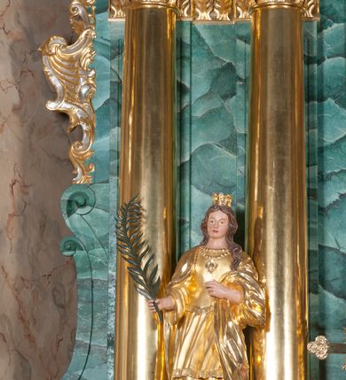 Zdjęcie nr 5: Nastawa ołtarzowa architektoniczna, jednokondygnacyjna, trójosiowa ze zwieńczeniem. 
Mensa w typie sarkofagowym, na niej rozbudowane, architektoniczne, dwukondygnacyjne, trójosiowe tabernakulum o wklęsło-wypukłej strukturze. Dolną kondygnację tabernakulum stanowi dwudzielny cokół przerwany w części środkowej na szafkę zamykaną drzwiczkami zdobionymi symbolami eucharystycznymi. Drugą kondygnację stanowi tron wystawienia – półkolista wnęka zdobiona motywem kiści winogron, z gołębicą Ducha Świętego na podniebieniu. Tron jest flankowany wnękami z dekoracją rocaille'ową oraz parami kolumn na tle pilastrów. Na dźwiganym przez kolumny rozbudowanym belkowaniu przeciwstawnie ustawione anioły kierują swój wzrok na krucyfiks. Zwieńczenie osi centralnej stanowi posążek baranka stojącego na księdze z siedmioma pieczęciami. 
Nastawa ołtarzowa jest oparta na wysokim, dwudzielnym cokole. Pole środkowe wypełnia nisza w kształcie stojącego prostokąta zamkniętego półkoliście z umieszczonym w niej obrazem Serca Pana Jezusa, powyżej którego znajduje się utworzony z motywów płomienistych rocaille'ów kartusz z koroną umieszczoną ponad dwoma skrzyżowanymi berłami. Pole centralne flankowane parami kolumn o rozbudowanych, kompozytowych kapitelach złożonych ze stylizowanych liści akantu i palmety pomiędzy wolutami, stojącymi na tle pilastrów połączonych fryzem palmetowym. Między nimi figury świętych: Katarzyny po lewej stronie i Barbary po prawej. Nastawa ujęta uszami z rocaille'u i spływów wolutowych. Kolumny dźwigają wyłamane na ich osiach belkowanie dekorowane kimationem i ząbkowaniem, z przyczółkiem przerwanym na rozbudowaną kompozycję Trójcy Świętej. W centrum przedstawienia siedzą Chrystus trzymający obiema rękami krzyż łaciński oraz Bóg Ojciec błogosławiący prawą i trzymający berło w lewej ręce. Między nimi drugi symbol władzy królewskiej – jabłko zwieńczone krzyżem, stanowiące również odniesiecie do globu ziemskiego. Postacie tronują wśród chmur, w których umieszczono główki aniołków. Powyżej nich gołębica Ducha Świętego w centrum glorii promienistej stanowiącej tło dla przedstawienia.  
 Struktura marmoryzowana na kolor zielony i niebieski; kolumny, detale, figury oraz tabernakulum złocone i srebrzone, polichromia figur w partiach ciała naturalistyczna.
