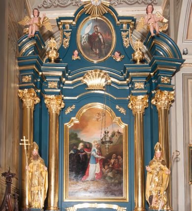 Zdjęcie nr 1: Ołtarz przyścienny, architektoniczny, jednoosiowy, jednokondygnacjowy ze zwieńczeniem. Retabulum ustawione na wysokim, dwukondygnacjowym  cokole o wyższej kondygnacji dolnej, z dwoma postumentami wyodrębnionymi po bokach;  powierzchnia cokołu dekorowana płycinami w kształcie prostokątów. Cokół przerwany w środku drzwiami do zakrystii ze skrzydłami w formie pionowych prostokątów podzielonych – każde skrzydło – na osiem mniejszych pól. Pole centralne ołtarza wypełnia obraz z przedstawieniem św. Kingi  odkrywającej złoża soli. Obraz ujęty w ramę w kształcie pionowego prostokąta zamkniętego łukiem wklęsło-wypukłym z uskokami; poniżej wstęga z inskrypcją „S(ANCTA) CUNEGUNDA ORA PRO NOBIS”. Pole z obrazem flankowane jest parami kolumn korynckich, z których zewnętrzne są wysunięte do przodu. Przed nie występują do przodu konsole na których ustawiono rzeźby św. Wojciecha i św. Stanisława. Kolumny dźwigają belkowanie przełamane na ich osiach i wygięte ku górze na linii płytkiego łuku odcinkowego powyżej obrazu;  pośrodku łuku dekoracja w formie dużej muszli. Na fryzie przełamanych fragmentów belkowania plakiety utworzone z dekoracji roślinnej; na osiach wewnętrznych kolumn, ponad belkowaniem, wazony z kwiatami. Ponad kolumnami zewnętrznymi i belkowaniem widoczne rozsunięte odcinki półkolistego, pękniętego przyczółka, na których posadowiono figurki aniołków. Pomiędzy odcinkami przyczółka zwieńczenie o formie ścianki w ogólnym kształcie zbliżonej do trapezu, o wklęsłych bokach zakończonych u dołu wolutami,  zamkniętej łukiem nadwieszonym; ścianka od góry zwieńczona częściowo niepełnym belkowaniem. Owalne pole pośrodku zwieńczenia wypełnia obraz z przedstawieniem św. Floriana; po bokach ramy rozmieszczone główki anielskie i plakiety z dekoracją roślinną. Ponad obrazem, na tle gzymsu belkowania od góry zamykającego zwieńczenie, widoczny medalion z monogramem Chrystusa otoczony obłokami, na tle glorii promienistej.  
Struktura retabulum malowana na kolor niebieski; profile, kolumny, ornamenty, detale złocone; figury oraz gloria złocone i srebrzone.
