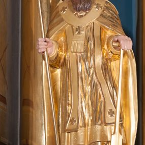 Zdjęcie nr 1: Figura pełna na niewysokim cokole. Święty Wojciech przedstawiony w całej postaci, stojący frontalnie, w lekkim kontrapoście, z lewą nogą zgiętą w kolanie. Obie ręce zgięte w łokciach, w prawej trzyma ferulę, czyli pastorał zakończony podwójnym krzyżem, lewą przytrzymuje oparte o ziemię wiosło. Wojciech ma pociągła twarz z zapadniętymi policzkami, małe oczy, wąski nos i małe, intensywnie czerwone usta. Długie włosy spływają mu na barki i plecy, gęsta, długa broda układa się w pukle. Jest ubrany w strój biskupi: albę, rokietę zdobioną pasem koronki przy dolnej krawędzi i stułę z aplikowanymi krzyżami greckimi. Na to założoną ma obszerną kapę, która spięta pod szyją okrywa ramiona i spływa do ziemi, na wierzchu paliusz. Szaty drobnymi, równoległymi fałdami opadają wzdłuż ciała ku ziemi. Na głowie ma infułę.  
Włosy i zarost brązowe, polichromia w odkrytych partiach karnacji postaci traktowana naturalistycznie, szaty i atrybuty złocone.
