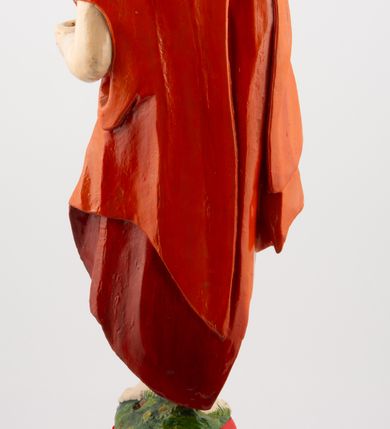 Zdjęcie nr 6: Rzeźba pełnoplastyczna, z tyłu opracowana, ustawiona na niewysokim cokole. Postać zwrócona frontalnie do widza, w kontrapoście, o esowato wygiętej sylwetce. W lewej ręce trzymał chorągiew, prawą unosi wysoko do góry w geście błogosławieństwa. Ciało o wyraźnie rzeźbionej muskulaturze z zaznaczonymi śladami męki. Twarz szczupła, o podkreślonej linii kości policzkowych i długim, prostym nosie, z dużymi oczami. Twarz okolona zarostem, włosy długie, gęste, z przedziałkiem na środku głowy, opadające na plecy. Przez biodra przepasane złote perizonium; pod szyją zapięty czerwony płaszcz opadający na plecy i lewe ramię. Karnacja ciała naturalistyczna, perizonium złocone.
