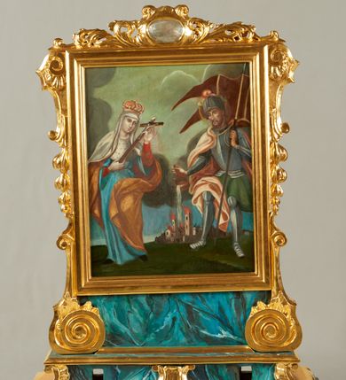 Zdjęcie nr 2: Pole obrazowe w formie stojącego prostokąta, ujęte profilowaną ramą oraz flankowane konsolami z podwieszonymi kampanulami przechodzącymi w spływy wolutowe stanowiące podstawę. Ramę wieńczy ornamentalny szczyt z akantu z owalnym kartuszem. Obraz na podstawie w formie profilowanego, zwężającego się ku górze cokołu, ujętego po bokach spływami wolutowymi, dekorowana fragmentami stylizowanej muszli, z dwoma otworami na drążki. 
Na awersie obraz Matki Boskiej z Dzieciątkiem i klęczącymi wiernymi. W centrum Maria stojąca na globie i sierpie księżyca, ukazana frontalnie, z głową skierowaną w lewo. Prawą ręką podtrzymuje Dzieciątko, lewą wyciąga w bok, trzymając pasek. Ubrana jest w różową suknię, przepasaną w talii, niebieski płaszcz przerzucony przez prawe ramię i zawinięty z przodu postaci, na głowie ma biały welon. Dzieciątko w pozycji siedzącej, zwrócone w trzech czwartych w lewo, przechylone w prawo, lewą ręką obejmuje Matkę, prawą wyciąga, w dłoni trzyma pasek. Ukazane jaki niemal nagie, przewiązane białą pieluszką. Po lewej stronie Marii klęczy kobieta, zwrócona w trzech czwartych w prawo, z uniesioną głową. Prawą wyciągniętą w górę ręką trzyma pasek, w lewej opuszczonej trzyma różaniec. Ubrana jest w białą koszulę, zielony gorset, czerwoną spódnicę z białą zapaską, na głowie ma biały czepek, na ramiona narzuconą białą chustę. Po prawej stronie Marii klęczy mężczyzna, zwrócony w trzech czwartych w lewo, z uniesioną głową. W lewej wyciągniętej w górę ręce trzyma pasek, w prawej ugiętej trzyma różaniec. Ma szczupłą twarz, krótkie, podgolone włosy oraz wąsy. Ubrany jest w niebieska sukmanę, przepasaną brązowym pasem, na nogach ma wysokie buty. Postacie ukazane na tle pejzażu z zachmurzonym niebem, rozjaśnionym wokół postaci Marii. 
Na rewersie całopostaciowe przestawienia św. Jadwigi i św. Floriana. W lewej części obrazu św. Jadwiga ukazana frontalnie, w kontrapoście, przechylona w lewo, obiema rekami podtrzymuje krucyfiks. Twarz ma pociągłą, o małych oczach, prostym nosie i pełnych ustach. Ubrana jest w czerwona suknię spodnią i jasnoniebieską suknię wierzchnią, przepasaną w talii. Na ramiona ma narzucony jasnobrązowy płaszcz z gronostajowa pelerynką, na głowie ma biały welon i zamkniętą koronę. W prawej części obrazu ukazany św. Florian, zwrócony w trzech czwartych w prawo, lekko pochylony, wlewej ręce trzyma drzewce chorągwi, w prawej wiaderko, z którego wylewa wodę na stojący poniżej palące się budynki. Twarz ma szczupłą, o małych oczach, garbatym nosie i małych ustach, okoloną krótkimi, brązowymi włosami i brodą. Ubrany jest w zieloną tunikę i zbroję, przez prawe ramię ma przerzucony jasnopomarańczowy płaszcz, na głowie ma hełm z pióropuszem. Postacie ukazane na tle pejzażu z zachmurzonym niebem, rozjaśnionym pośrodku. 








