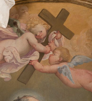 Zdjęcie nr 14: Owalny obraz, w drewnianej, profilowanej, złoconej ramie ukazuje klęczącego św. Józefa z siedzącym na chmurach Jezusem w towarzystwie grającego na kontrabasie anioła, grup uskrzydlonych puttów i główek anielskich. Józef ukazany jest w trzech czwartych, z lewą ręką obejmującą Jezusa, a prawą, zgiętą w łokciu i wyciągniętą do przodu. Głowa z łysiną czołową i siwymi, kręconymi, krótkimi włosami; twarz o rysach starszego mężczyzny, z krótkim nosem i otwartymi oczami. Święty ubrany jest w jasnofioletową suknię i brązowy płaszcz okrywający niemal cała sylwetkę. Siedzący na chmurze z trzema główkami aniołków nagi Jezus głowę zwraca ku górze i wysoko unosi rączki. Jego twarz jest pełna, policzki pękate, zaczerwienione, oczy ciemnobrązowe, krótki nosek i otwarte, pełne usta, włosy krótkie, jasne, kręcone.  Po prawej stronie klęczy anioł grający na kontrabasie, ukazany w trzech czwartych, zwrócony głową w prawo, ubrany w niebieską suknię odsłaniającą lewą pierś i bladoczerwony płaszcz. Jego głowa jest przedstawiona z profilu, z gęstymi, kręconymi, blond włosami, opadającymi na ramiona. Twarz ma pociągłą, z długim, zadartym nosem, otwartymi oczami i różowymi, otwartymi ustami. Przed św. Józefem siedzi para aniołków, z których jeden trzyma długi kij zakończony lilią. W górnej strefie wyłaniają się z chmur główki aniołków i dwa uskrzydlone aniołki trzymające krzyż. Tło nieokreślone, w tonacjach szarości, z widoczną dolną częścią kolumny. 
