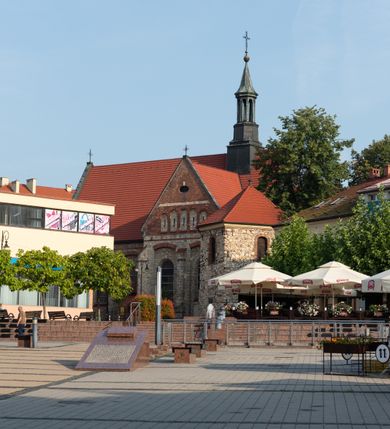 Zdjęcie nr 46: Kościół murowany, orientowany, jednonawowy, trójprzęsłowy, z transeptem i jednoprzęsłowym, węższym i niższym prezbiterium zamkniętym trójbocznie. Między nawą a transeptem po obu stronach znajdują się kruchty, do prezbiterium od strony północnej dostawiona kruchta złożona z dwóch lokalności. Ściany są rozczłonkowane filarami, tworzącymi płytkie arkadowe wnęki. Między nawą a prezbiterium arkada tęczowa. Sklepienie krzyżowe na gurtach spływających na filary. Prezbiterium oświetlają wąskie, prostokątne okna zamknięte ostrołukowo, w nawie i w transepcie znajdują się prostokątne okna prostokątne zamknięte półkoliście, w ścianie frontowej w dolnej części okna prostokątne zamknięte półkoliście, a w górnej podwójne okna prostokątne. Fasada ujęta dwiema narożnymi szkarpami, zwieńczona trójkątnie. Do niej dostawiona kruchta z dwuspadowym daszkiem i wejściem w kształcie prostokąta zamkniętego półkoliście. W kamiennej fasadzie znajdują się dołem okna prostokątne, zamknięte półkoliście, a górą  prostokątne, biforialne okna z nadprożem łukowatym wykonanym z cegły. Szczyt ceglany, podzielony na trzy strefy kamiennym wątkiem, z pięcioma wnękami prostokątnymi, zamkniętymi półkoliście, z wąskimi otworami w dolnej strefie i z owalnym oknem w drugiej. Elewacje boczne nawy ujęte skarpami. Dachy dwuspadowe, kryte dachówką, z wieżyczką na sygnaturkę.         