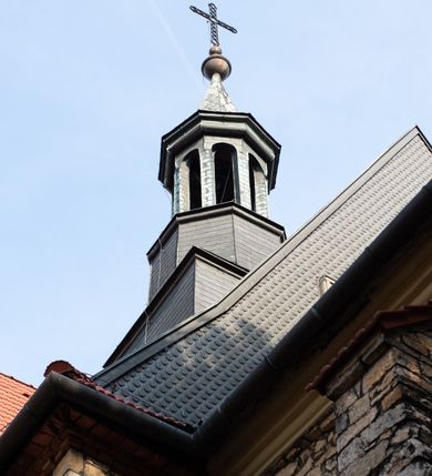 Zdjęcie nr 12: Kościół murowany, orientowany, jednonawowy, trójprzęsłowy, z transeptem i jednoprzęsłowym, węższym i niższym prezbiterium zamkniętym trójbocznie. Między nawą a transeptem po obu stronach znajdują się kruchty, do prezbiterium od strony północnej dostawiona kruchta złożona z dwóch lokalności. Ściany są rozczłonkowane filarami, tworzącymi płytkie arkadowe wnęki. Między nawą a prezbiterium arkada tęczowa. Sklepienie krzyżowe na gurtach spływających na filary. Prezbiterium oświetlają wąskie, prostokątne okna zamknięte ostrołukowo, w nawie i w transepcie znajdują się prostokątne okna prostokątne zamknięte półkoliście, w ścianie frontowej w dolnej części okna prostokątne zamknięte półkoliście, a w górnej podwójne okna prostokątne. Fasada ujęta dwiema narożnymi szkarpami, zwieńczona trójkątnie. Do niej dostawiona kruchta z dwuspadowym daszkiem i wejściem w kształcie prostokąta zamkniętego półkoliście. W kamiennej fasadzie znajdują się dołem okna prostokątne, zamknięte półkoliście, a górą  prostokątne, biforialne okna z nadprożem łukowatym wykonanym z cegły. Szczyt ceglany, podzielony na trzy strefy kamiennym wątkiem, z pięcioma wnękami prostokątnymi, zamkniętymi półkoliście, z wąskimi otworami w dolnej strefie i z owalnym oknem w drugiej. Elewacje boczne nawy ujęte skarpami. Dachy dwuspadowe, kryte dachówką, z wieżyczką na sygnaturkę.         