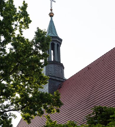 Zdjęcie nr 47: Kościół murowany, orientowany, jednonawowy, trójprzęsłowy, z transeptem i jednoprzęsłowym, węższym i niższym prezbiterium zamkniętym trójbocznie. Między nawą a transeptem po obu stronach znajdują się kruchty, do prezbiterium od strony północnej dostawiona kruchta złożona z dwóch lokalności. Ściany są rozczłonkowane filarami, tworzącymi płytkie arkadowe wnęki. Między nawą a prezbiterium arkada tęczowa. Sklepienie krzyżowe na gurtach spływających na filary. Prezbiterium oświetlają wąskie, prostokątne okna zamknięte ostrołukowo, w nawie i w transepcie znajdują się prostokątne okna prostokątne zamknięte półkoliście, w ścianie frontowej w dolnej części okna prostokątne zamknięte półkoliście, a w górnej podwójne okna prostokątne. Fasada ujęta dwiema narożnymi szkarpami, zwieńczona trójkątnie. Do niej dostawiona kruchta z dwuspadowym daszkiem i wejściem w kształcie prostokąta zamkniętego półkoliście. W kamiennej fasadzie znajdują się dołem okna prostokątne, zamknięte półkoliście, a górą  prostokątne, biforialne okna z nadprożem łukowatym wykonanym z cegły. Szczyt ceglany, podzielony na trzy strefy kamiennym wątkiem, z pięcioma wnękami prostokątnymi, zamkniętymi półkoliście, z wąskimi otworami w dolnej strefie i z owalnym oknem w drugiej. Elewacje boczne nawy ujęte skarpami. Dachy dwuspadowe, kryte dachówką, z wieżyczką na sygnaturkę.         