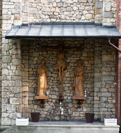 Zdjęcie nr 54: Kościół murowany, orientowany, jednonawowy, trójprzęsłowy, z transeptem i jednoprzęsłowym, węższym i niższym prezbiterium zamkniętym trójbocznie. Między nawą a transeptem po obu stronach znajdują się kruchty, do prezbiterium od strony północnej dostawiona kruchta złożona z dwóch lokalności. Ściany są rozczłonkowane filarami, tworzącymi płytkie arkadowe wnęki. Między nawą a prezbiterium arkada tęczowa. Sklepienie krzyżowe na gurtach spływających na filary. Prezbiterium oświetlają wąskie, prostokątne okna zamknięte ostrołukowo, w nawie i w transepcie znajdują się prostokątne okna prostokątne zamknięte półkoliście, w ścianie frontowej w dolnej części okna prostokątne zamknięte półkoliście, a w górnej podwójne okna prostokątne. Fasada ujęta dwiema narożnymi szkarpami, zwieńczona trójkątnie. Do niej dostawiona kruchta z dwuspadowym daszkiem i wejściem w kształcie prostokąta zamkniętego półkoliście. W kamiennej fasadzie znajdują się dołem okna prostokątne, zamknięte półkoliście, a górą  prostokątne, biforialne okna z nadprożem łukowatym wykonanym z cegły. Szczyt ceglany, podzielony na trzy strefy kamiennym wątkiem, z pięcioma wnękami prostokątnymi, zamkniętymi półkoliście, z wąskimi otworami w dolnej strefie i z owalnym oknem w drugiej. Elewacje boczne nawy ujęte skarpami. Dachy dwuspadowe, kryte dachówką, z wieżyczką na sygnaturkę.         