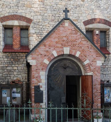 Zdjęcie nr 51: Kościół murowany, orientowany, jednonawowy, trójprzęsłowy, z transeptem i jednoprzęsłowym, węższym i niższym prezbiterium zamkniętym trójbocznie. Między nawą a transeptem po obu stronach znajdują się kruchty, do prezbiterium od strony północnej dostawiona kruchta złożona z dwóch lokalności. Ściany są rozczłonkowane filarami, tworzącymi płytkie arkadowe wnęki. Między nawą a prezbiterium arkada tęczowa. Sklepienie krzyżowe na gurtach spływających na filary. Prezbiterium oświetlają wąskie, prostokątne okna zamknięte ostrołukowo, w nawie i w transepcie znajdują się prostokątne okna prostokątne zamknięte półkoliście, w ścianie frontowej w dolnej części okna prostokątne zamknięte półkoliście, a w górnej podwójne okna prostokątne. Fasada ujęta dwiema narożnymi szkarpami, zwieńczona trójkątnie. Do niej dostawiona kruchta z dwuspadowym daszkiem i wejściem w kształcie prostokąta zamkniętego półkoliście. W kamiennej fasadzie znajdują się dołem okna prostokątne, zamknięte półkoliście, a górą  prostokątne, biforialne okna z nadprożem łukowatym wykonanym z cegły. Szczyt ceglany, podzielony na trzy strefy kamiennym wątkiem, z pięcioma wnękami prostokątnymi, zamkniętymi półkoliście, z wąskimi otworami w dolnej strefie i z owalnym oknem w drugiej. Elewacje boczne nawy ujęte skarpami. Dachy dwuspadowe, kryte dachówką, z wieżyczką na sygnaturkę.         