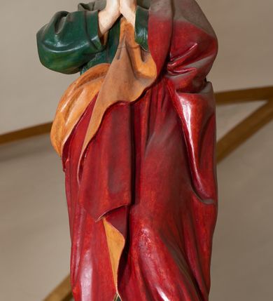 Zdjęcie nr 9: Grupa Ukrzyżowania złożona z ukrzyżowanego Chrystusa w typie christo vivo, stojących postaci Matki Boskiej i św. Jana oraz klęczącej Marii Magdaleny. Figura Chrystusa jest rzeźbą pełnoplastyczną, nieznacznie ściętą z tyłu, pozostałe są ścięte i wydrążone od tyłu. Zbawiciel przybity trzema gwoździami, z niemal prosto rozpostartymi rękami, z głową przechyloną na prawe ramię. Jego twarz jest pociągła, nos długi, oczy otwarte, twarz okolona kręconą, brązową brodą na głowie kręcone, sięgające szyi włosy i korona cierniowa pomalowana na zielono. Ręce z wyłamanymi barkami, z uwidocznionymi ścięgnami, klatka piersiowa wybrzuszona, z widocznymi żebrami i mostkiem, nogi smukłe z wyeksponowanymi kośćmi i mięśniami. Złocone perizonium przepasane podwójnym sznurem, z dwiema swobodnie rozwianymi połami po obu stronach bioder. Na naturalistycznie oddanym ciele zaznaczone strużki krwi. Na górnej belce titulus z literami: INRI". 
Matka Boska przedstawiona w pozycji stojącej, w kontrapoście, z rękami skrzyżowanymi na piersi. Głowę zwraca w kierunku Chrystusa, jej twarz jest owalna, włosy długie, brązowe, opadające na ramiona. Ubrana jest w czerwoną suknię z żółtą lamówką na rękawach, niebieski płaszcz o żółtym podbiciu i białą, długą chustę na głowie.    
Święty Jan ukazany w pozycji stojącej, w kontrapoście, z rękami złożonymi w geście modlitwy. Jego twarz jest owalna, oczy szeroko otwarte, włosy brązowe, kręcone, opadające na ramiona. Apostoł jest ubrany w zieloną tunikę i czerwony płaszcz z pomarańczowym podbiciem, przewieszony przez lewe ramię i ugiętą rękę. 
Po prawej stronie krzyża klęczy Maria Magdalena, ukazana prawym profilem, z prawą ręką, w której trzyma gąbkę wyciągniętą ku krzyżowi. Jej twarz jest pociągła z prostym nosem, włosy jasnobrązowe, długie, kręcone, opadające na plecy. Jest ubrana w zieloną tunikę i brązowy płaszcz o jaśniejszym podbiciu, opadający z lewego ramienia.
Na belce w kolorze czerwonym złocony napis: "Benedictus XVI SPE SALVI FACTI SUMUS A(NNO) D(OMINI) MMVII".
