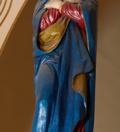 Zdjęcie nr 4: Grupa Ukrzyżowania złożona z ukrzyżowanego Chrystusa w typie christo vivo, stojących postaci Matki Boskiej i św. Jana oraz klęczącej Marii Magdaleny. Figura Chrystusa jest rzeźbą pełnoplastyczną, nieznacznie ściętą z tyłu, pozostałe są ścięte i wydrążone od tyłu. Zbawiciel przybity trzema gwoździami, z niemal prosto rozpostartymi rękami, z głową przechyloną na prawe ramię. Jego twarz jest pociągła, nos długi, oczy otwarte, twarz okolona kręconą, brązową brodą na głowie kręcone, sięgające szyi włosy i korona cierniowa pomalowana na zielono. Ręce z wyłamanymi barkami, z uwidocznionymi ścięgnami, klatka piersiowa wybrzuszona, z widocznymi żebrami i mostkiem, nogi smukłe z wyeksponowanymi kośćmi i mięśniami. Złocone perizonium przepasane podwójnym sznurem, z dwiema swobodnie rozwianymi połami po obu stronach bioder. Na naturalistycznie oddanym ciele zaznaczone strużki krwi. Na górnej belce titulus z literami: INRI". 
Matka Boska przedstawiona w pozycji stojącej, w kontrapoście, z rękami skrzyżowanymi na piersi. Głowę zwraca w kierunku Chrystusa, jej twarz jest owalna, włosy długie, brązowe, opadające na ramiona. Ubrana jest w czerwoną suknię z żółtą lamówką na rękawach, niebieski płaszcz o żółtym podbiciu i białą, długą chustę na głowie.    
Święty Jan ukazany w pozycji stojącej, w kontrapoście, z rękami złożonymi w geście modlitwy. Jego twarz jest owalna, oczy szeroko otwarte, włosy brązowe, kręcone, opadające na ramiona. Apostoł jest ubrany w zieloną tunikę i czerwony płaszcz z pomarańczowym podbiciem, przewieszony przez lewe ramię i ugiętą rękę. 
Po prawej stronie krzyża klęczy Maria Magdalena, ukazana prawym profilem, z prawą ręką, w której trzyma gąbkę wyciągniętą ku krzyżowi. Jej twarz jest pociągła z prostym nosem, włosy jasnobrązowe, długie, kręcone, opadające na plecy. Jest ubrana w zieloną tunikę i brązowy płaszcz o jaśniejszym podbiciu, opadający z lewego ramienia.
Na belce w kolorze czerwonym złocony napis: "Benedictus XVI SPE SALVI FACTI SUMUS A(NNO) D(OMINI) MMVII".
