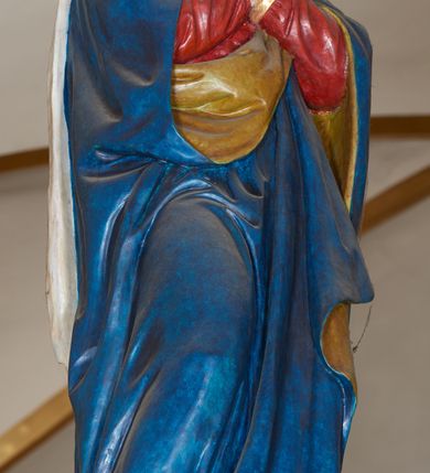 Zdjęcie nr 5: Grupa Ukrzyżowania złożona z ukrzyżowanego Chrystusa w typie christo vivo, stojących postaci Matki Boskiej i św. Jana oraz klęczącej Marii Magdaleny. Figura Chrystusa jest rzeźbą pełnoplastyczną, nieznacznie ściętą z tyłu, pozostałe są ścięte i wydrążone od tyłu. Zbawiciel przybity trzema gwoździami, z niemal prosto rozpostartymi rękami, z głową przechyloną na prawe ramię. Jego twarz jest pociągła, nos długi, oczy otwarte, twarz okolona kręconą, brązową brodą na głowie kręcone, sięgające szyi włosy i korona cierniowa pomalowana na zielono. Ręce z wyłamanymi barkami, z uwidocznionymi ścięgnami, klatka piersiowa wybrzuszona, z widocznymi żebrami i mostkiem, nogi smukłe z wyeksponowanymi kośćmi i mięśniami. Złocone perizonium przepasane podwójnym sznurem, z dwiema swobodnie rozwianymi połami po obu stronach bioder. Na naturalistycznie oddanym ciele zaznaczone strużki krwi. Na górnej belce titulus z literami: INRI&quot;. 
Matka Boska przedstawiona w pozycji stojącej, w kontrapoście, z rękami skrzyżowanymi na piersi. Głowę zwraca w kierunku Chrystusa, jej twarz jest owalna, włosy długie, brązowe, opadające na ramiona. Ubrana jest w czerwoną suknię z żółtą lamówką na rękawach, niebieski płaszcz o żółtym podbiciu i białą, długą chustę na głowie.    
Święty Jan ukazany w pozycji stojącej, w kontrapoście, z rękami złożonymi w geście modlitwy. Jego twarz jest owalna, oczy szeroko otwarte, włosy brązowe, kręcone, opadające na ramiona. Apostoł jest ubrany w zieloną tunikę i czerwony płaszcz z pomarańczowym podbiciem, przewieszony przez lewe ramię i ugiętą rękę. 
Po prawej stronie krzyża klęczy Maria Magdalena, ukazana prawym profilem, z prawą ręką, w której trzyma gąbkę wyciągniętą ku krzyżowi. Jej twarz jest pociągła z prostym nosem, włosy jasnobrązowe, długie, kręcone, opadające na plecy. Jest ubrana w zieloną tunikę i brązowy płaszcz o jaśniejszym podbiciu, opadający z lewego ramienia.
Na belce w kolorze czerwonym złocony napis: &quot;Benedictus XVI SPE SALVI FACTI SUMUS A(NNO) D(OMINI) MMVII&quot;.
