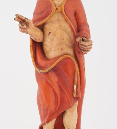 Zdjęcie nr 3: Pełnoplastyczna rzeźba Chrystusa Zmartwychwstałego stojącego na chmurze z prawą ręką wzniesioną w geście błogosławieństwa, lewą trzymającego krzyż na długim drzewcu. Twarz szeroka, z wydatnym nosem, ciemnobrązowymi oczami, ciemnoróżowymi ustami, okolona zarostem oraz włosami z przedziałkiem pośrodku głowy, opadającymi na plecy. Karnacja jasnobeżowa. Chrystus ukazany nagi, przesłonięty czerwonym płaszczem, spiętym na piersi, opadającym ukośnymi fałdami do ziemi. 