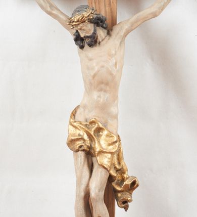 Zdjęcie nr 1: Figura pełnoplastyczna, lekko obcięta z tyłu. Rzeźba ukazuje Chrystusa przybitego do krzyża trzema gwoździami, w silnym zwisie, o subtelnie zarysowanej esowato sylwetce. Jego twarz jest modelowana sumarycznie, a rysy zatarte nadmierną ilością farby, z zaznaczoną czarną brodą, włosami opadającymi na kark i prawe ramię oraz złoconą koroną cierniową. Ciało jest smukłe, delikatnie kształtowane, z lekko zaznaczonym mostkiem i żebrami, z miękko układającym się perizonium o ekspresyjnie zawiniętym i luźno wijącym się brzegu. Na górnej belce krzyża titulus z napisem: „IN/RI”. 