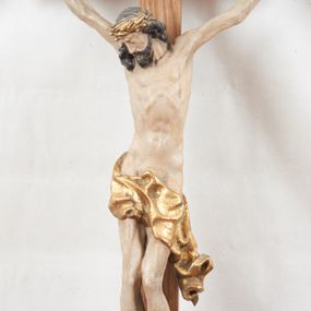 Zdjęcie nr 1: Figura pełnoplastyczna, lekko obcięta z tyłu. Rzeźba ukazuje Chrystusa przybitego do krzyża trzema gwoździami, w silnym zwisie, o subtelnie zarysowanej esowato sylwetce. Jego twarz jest modelowana sumarycznie, a rysy zatarte nadmierną ilością farby, z zaznaczoną czarną brodą, włosami opadającymi na kark i prawe ramię oraz złoconą koroną cierniową. Ciało jest smukłe, delikatnie kształtowane, z lekko zaznaczonym mostkiem i żebrami, z miękko układającym się perizonium o ekspresyjnie zawiniętym i luźno wijącym się brzegu. Na górnej belce krzyża titulus z napisem: „IN/RI”. 