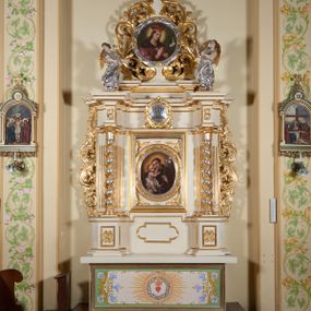 Zdjęcie nr 1: Ołtarz architektoniczny, jednokondygnacyjny, jednoosiowy, ze zwieńczeniem. Mensa drewniana, antepedium drewniane, nowe, z malowanym gorejącym sercem otoczonym koroną cierniową i promienistą glorią. Retabulum na niewysokim cokole z uskokowymi postumentami, ujęte parą półfilarów o żłobkowanych trzonach i ustawionych na ich tle kolumn o spiralnie skręconych trzonach, wspierających wyłamujące się ponad nimi belkowanie z silnie wysuniętym gzymsem. Boki ołtarza ujęte akantowymi liśćmi, srebrzone trzony kolumn przeplecione złoconymi liśćmi. W centrum prostokątna wnęka w profilowanej ramie z owalnym obrazem z przedstawieniem św. Antoniego z Dzieciątkiem. Nad wnęką kartusz z napisem: „JEZU / UFAM / TOBIE”. Zwieńczenie utworzone z okrągłego obrazu z wizerunkiem św. Kazimierza w srebrzonej ramie na kształt wieńca laurowego obwiedzionego liśćmi akantu, które przechodzą dołem w karbowaną wstęgę regencyjną; w górnej części zwieńczenia gołębica Ducha Świętego na tle promieni. Po bokach zwieńczenia dwa stojące anioły. Struktura polichromowana w kolorze jasnego beżu, ornamentyka i partie detalu architektonicznego złocone i srebrzone.   

