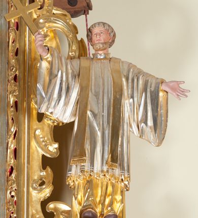 Zdjęcie nr 5: Ołtarz architektoniczny, jednokondygnacyjny, jednoosiowy, ze zwieńczeniem. Jego mensa i antepedium są drewniane. Antepedium w kształcie leżącego prostokąta zostało ujęte profilowaną, złoconą ramą, a wypełnione dekoracją malarską z motywem krzyża i białych lilii pośrodku, ujętych ornamentalną bordiurą ze stylizowanych motywów roślinno-kwiatowych. Retabulum jest osadzone na niewysokim cokole i ujęte kolumnami korynckimi, dźwigającymi wyłamujące się ponad nimi, przerwane w partii architrawu i fryzu belkowanie z silnie wysuniętym gzymsem. Do kolumn dostawione po bokach ażurowe uszaki formowane z ornamentu małżowinowo-chrząstkowego, z parą wazonów z kwiatami w połowie wysokości. Trzony kolumn są pokryte płaskorzeźbionymi gałązkami winorośli. W partiach fryzu belkowania widnieje motyw rozetek; na cokołach ornamenty małżowinowe. Gzyms zdobiony drobną ornamentyką roślinną, pośrodku kolista gloria z Okiem Opatrzności. Zwieńczenie na niewysokim cokole o zryzalitowanych bokach, w kształcie stojącego prostokąta o wciętych górnych narożach. Nad nim szczyt w formie owalnego kartusza o fantazyjnym wykroju. Zwieńczenie jest ujęte parą ażurowych uszaków w formie ornamentu małżowinowo–chrząstkowego. Pole środkowe retabulum w kształcie stojącego prostokąta, ujętego profilowaną, złoconą ramą zdobioną ażurową ornamentyką małżowinowo-chrząstkową. Wewnątrz płaskorzeźba ukazująca św. Józefa z Jezusem. Pole zwieńczenia w kształcie stojącego prostokąta zamkniętego nadwieszonym łukiem, ujęte profilowaną, złoconą ramą z ażurową ornamentyką małżowinowo-chrząstkową. W nim obraz „Komunia św. Stanisława Kostki”. Pole szczytu w kształcie leżącego owalu z obrazem Matki Boskiej Częstochowskiej. Zwieńczenie jest flankowane ustawionymi na zryzalitowanych cokołach figurami św. Stanisława biskupa i św. Jacka (?). Struktura polichromowana w kolorze jasnego beżu. Ornamentyka i partie detalu architektonicznego złocone i srebrzone. 
