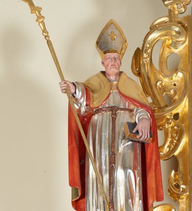 Zdjęcie nr 4: Ołtarz architektoniczny, jednokondygnacyjny, jednoosiowy, ze zwieńczeniem. Jego mensa i antepedium są drewniane. Antepedium w kształcie leżącego prostokąta zostało ujęte profilowaną, złoconą ramą, a wypełnione dekoracją malarską z motywem krzyża i białych lilii pośrodku, ujętych ornamentalną bordiurą ze stylizowanych motywów roślinno-kwiatowych. Retabulum jest osadzone na niewysokim cokole i ujęte kolumnami korynckimi, dźwigającymi wyłamujące się ponad nimi, przerwane w partii architrawu i fryzu belkowanie z silnie wysuniętym gzymsem. Do kolumn dostawione po bokach ażurowe uszaki formowane z ornamentu małżowinowo-chrząstkowego, z parą wazonów z kwiatami w połowie wysokości. Trzony kolumn są pokryte płaskorzeźbionymi gałązkami winorośli. W partiach fryzu belkowania widnieje motyw rozetek; na cokołach ornamenty małżowinowe. Gzyms zdobiony drobną ornamentyką roślinną, pośrodku kolista gloria z Okiem Opatrzności. Zwieńczenie na niewysokim cokole o zryzalitowanych bokach, w kształcie stojącego prostokąta o wciętych górnych narożach. Nad nim szczyt w formie owalnego kartusza o fantazyjnym wykroju. Zwieńczenie jest ujęte parą ażurowych uszaków w formie ornamentu małżowinowo–chrząstkowego. Pole środkowe retabulum w kształcie stojącego prostokąta, ujętego profilowaną, złoconą ramą zdobioną ażurową ornamentyką małżowinowo-chrząstkową. Wewnątrz płaskorzeźba ukazująca św. Józefa z Jezusem. Pole zwieńczenia w kształcie stojącego prostokąta zamkniętego nadwieszonym łukiem, ujęte profilowaną, złoconą ramą z ażurową ornamentyką małżowinowo-chrząstkową. W nim obraz „Komunia św. Stanisława Kostki”. Pole szczytu w kształcie leżącego owalu z obrazem Matki Boskiej Częstochowskiej. Zwieńczenie jest flankowane ustawionymi na zryzalitowanych cokołach figurami św. Stanisława biskupa i św. Jacka (?). Struktura polichromowana w kolorze jasnego beżu. Ornamentyka i partie detalu architektonicznego złocone i srebrzone. 
