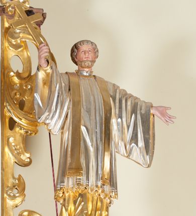 Zdjęcie nr 7: Ołtarz architektoniczny, jednokondygnacyjny, jednoosiowy, ze zwieńczeniem. Jego mensa i antepedium są drewniane. Antepedium w kształcie leżącego prostokąta zostało ujęte profilowaną, złoconą ramą, a wypełnione dekoracją malarską z motywem krzyża i białych lilii pośrodku, ujętych ornamentalną bordiurą ze stylizowanych motywów roślinno-kwiatowych. Retabulum jest osadzone na niewysokim cokole i ujęte kolumnami korynckimi, dźwigającymi wyłamujące się ponad nimi, przerwane w partii architrawu i fryzu belkowanie z silnie wysuniętym gzymsem. Do kolumn dostawione po bokach ażurowe uszaki formowane z ornamentu małżowinowo-chrząstkowego, z parą wazonów z kwiatami w połowie wysokości. Trzony kolumn są pokryte płaskorzeźbionymi gałązkami winorośli. W partiach fryzu belkowania widnieje motyw rozetek; na cokołach ornamenty małżowinowe. Gzyms zdobiony drobną ornamentyką roślinną, pośrodku kolista gloria z Okiem Opatrzności. Zwieńczenie na niewysokim cokole o zryzalitowanych bokach, w kształcie stojącego prostokąta o wciętych górnych narożach. Nad nim szczyt w formie owalnego kartusza o fantazyjnym wykroju. Zwieńczenie jest ujęte parą ażurowych uszaków w formie ornamentu małżowinowo–chrząstkowego. Pole środkowe retabulum w kształcie stojącego prostokąta, ujętego profilowaną, złoconą ramą zdobioną ażurową ornamentyką małżowinowo-chrząstkową. Wewnątrz płaskorzeźba ukazująca św. Józefa z Jezusem. Pole zwieńczenia w kształcie stojącego prostokąta zamkniętego nadwieszonym łukiem, ujęte profilowaną, złoconą ramą z ażurową ornamentyką małżowinowo-chrząstkową. W nim obraz „Komunia św. Stanisława Kostki”. Pole szczytu w kształcie leżącego owalu z obrazem Matki Boskiej Częstochowskiej. Zwieńczenie jest flankowane ustawionymi na zryzalitowanych cokołach figurami św. Stanisława biskupa i św. Jacka (?). Struktura polichromowana w kolorze jasnego beżu. Ornamentyka i partie detalu architektonicznego złocone i srebrzone. 
