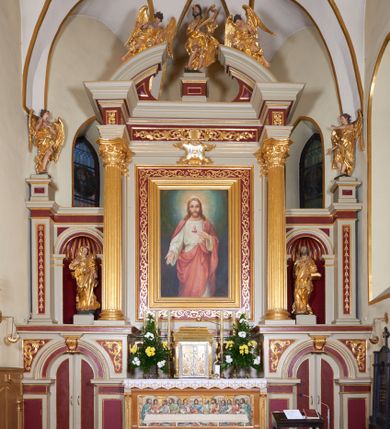 Zdjęcie nr 1: Ołtarz kamienny, prostopadłościenny z kamienną mensą, ustawiony na dwustopniowej podstawie. Antepedium flankowane pilastrami o kanelowanych trzonach; w polu płaskorzeźba z przedstawieniem Ostatniej Wieczerzy, ujęta ramą. Tabernakulum w formie drewnianej skrzynki obitej złoconą blachą. Ścianka frontowa flankowana parą kolumienek o kapitelach jońskich i kanelowanych trzonach, na cokołach, dźwigających pełne belkowanie opasujące tabernakulum z trzech stron. Drzwiczki ujęte karbowaną ramą, w formie stojącego prostokąta, w którego polu na fakturowanym tle odlane przedstawienia zbóż i winnego grona, flankujące aplikowane pośrodku chrysmon  z literami alfa i omega. Tron wystawienia w formie profilowanego cokołu ustawionego na tabernakulum.
Nastawa architektoniczna, trójosiowa, jednokondygnacyjna. Bramki na osiach bocznych w partii cokołowej w formie aediculi, zwieńczonej kluczem; całość zamknięta gzymsem; drzwiczki dwuskrzydłowe. Oś środkowa najwyższa, na cokole, ujęta parą pilastrów i stojących przed nimi kolumn o kapitelach kompozytowych i kanelowanych trzonach dźwigających pełne belkowanie wyłamane na ich osi oraz przerwany półokrągły przyczółek. Osie boczne flankowane z zewnątrz filarami dźwigającymi niepełny gzyms przechodzący przez całą ich szerokość, wyłamany na ich linii. 
Przyłucza arkad bramek dekorowane akantem. W predelli płyciny o geometrycznym wykroju. W polu środkowym obraz „Najświętsze Serce Jezusa” w ramie dekorowanej, malowanej na złoto wicią roślinną. Płyciny w filarach flankujących z zewnątrz ołtarz wypełnione malowanymi kampanulami. W polach osi bocznych nisze na figury św. Anny i św. Joachima. Na skrajnych filarach ołtarza cokoły z figurami aniołów. Na architrawie nad obrazem kartusz z monogramem IHS; fryz wypełniony płycinami: na osi kolumn z rozetami, nad polem stylizowanym akantem z muszlą.  Na przerwanym przyczółku leżąca para aniołów, pośrodku belkowania cokół z figurą króla Dawida. 
Struktura polichromowana w kolorze złamanej bieli, płyciny i pola w kolorze czerwonym, kolumny, ornamentyka i profile złocone.
