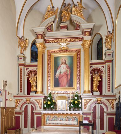 Zdjęcie nr 2: Ołtarz kamienny, prostopadłościenny z kamienną mensą, ustawiony na dwustopniowej podstawie. Antepedium flankowane pilastrami o kanelowanych trzonach; w polu płaskorzeźba z przedstawieniem Ostatniej Wieczerzy, ujęta ramą. Tabernakulum w formie drewnianej skrzynki obitej złoconą blachą. Ścianka frontowa flankowana parą kolumienek o kapitelach jońskich i kanelowanych trzonach, na cokołach, dźwigających pełne belkowanie opasujące tabernakulum z trzech stron. Drzwiczki ujęte karbowaną ramą, w formie stojącego prostokąta, w którego polu na fakturowanym tle odlane przedstawienia zbóż i winnego grona, flankujące aplikowane pośrodku chrysmon  z literami alfa i omega. Tron wystawienia w formie profilowanego cokołu ustawionego na tabernakulum.
Nastawa architektoniczna, trójosiowa, jednokondygnacyjna. Bramki na osiach bocznych w partii cokołowej w formie aediculi, zwieńczonej kluczem; całość zamknięta gzymsem; drzwiczki dwuskrzydłowe. Oś środkowa najwyższa, na cokole, ujęta parą pilastrów i stojących przed nimi kolumn o kapitelach kompozytowych i kanelowanych trzonach dźwigających pełne belkowanie wyłamane na ich osi oraz przerwany półokrągły przyczółek. Osie boczne flankowane z zewnątrz filarami dźwigającymi niepełny gzyms przechodzący przez całą ich szerokość, wyłamany na ich linii. 
Przyłucza arkad bramek dekorowane akantem. W predelli płyciny o geometrycznym wykroju. W polu środkowym obraz „Najświętsze Serce Jezusa” w ramie dekorowanej, malowanej na złoto wicią roślinną. Płyciny w filarach flankujących z zewnątrz ołtarz wypełnione malowanymi kampanulami. W polach osi bocznych nisze na figury św. Anny i św. Joachima. Na skrajnych filarach ołtarza cokoły z figurami aniołów. Na architrawie nad obrazem kartusz z monogramem IHS; fryz wypełniony płycinami: na osi kolumn z rozetami, nad polem stylizowanym akantem z muszlą.  Na przerwanym przyczółku leżąca para aniołów, pośrodku belkowania cokół z figurą króla Dawida. 
Struktura polichromowana w kolorze złamanej bieli, płyciny i pola w kolorze czerwonym, kolumny, ornamentyka i profile złocone.
