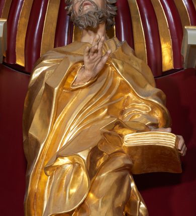 Zdjęcie nr 5: Święty Joachim został ukazany frontalnie, całopostaciowo, w lekkim kontrapoście, z prawą ręką wyciągniętą na piersi w geście błogosławieństwa, a lewą przytrzymującą księgę wspartą na biodrze. Jest ubrany w długą suknię i płaszcz spięty na piersi, okrywający plecy i przerzucony przez lewą nogę. Twarz o wydatnych policzkach, z głębokimi oczodołami, masywnym nosie i otwartymi ustami. Włosy krótkie, kręcone, układane w pojedyncze pukle; broda jest krótka, falująca.  
