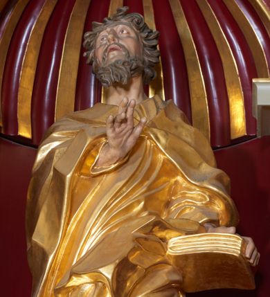 Zdjęcie nr 1: Święty Joachim został ukazany frontalnie, całopostaciowo, w lekkim kontrapoście, z prawą ręką wyciągniętą na piersi w geście błogosławieństwa, a lewą przytrzymującą księgę wspartą na biodrze. Jest ubrany w długą suknię i płaszcz spięty na piersi, okrywający plecy i przerzucony przez lewą nogę. Twarz o wydatnych policzkach, z głębokimi oczodołami, masywnym nosie i otwartymi ustami. Włosy krótkie, kręcone, układane w pojedyncze pukle; broda jest krótka, falująca.  
