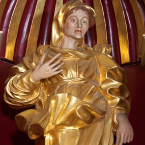 Zdjęcie nr 1: Święta Anna została ukazana frontalnie, całopostaciowo, w lekkim kontrapoście, z prawą ręką zgiętą w łokciu i uniesioną na wysokości piersi, a lewą opuszczoną wzdłuż ciała. Ubrana w długą suknię przewiązaną, płaszcz zarzucony na plecy i welon na głowie. Ma twarz o ostrych rysach, z wydatnymi kościami policzkowymi, szerokim, dużym nosem, otwartymi oczami i zamkniętymi ustami. 