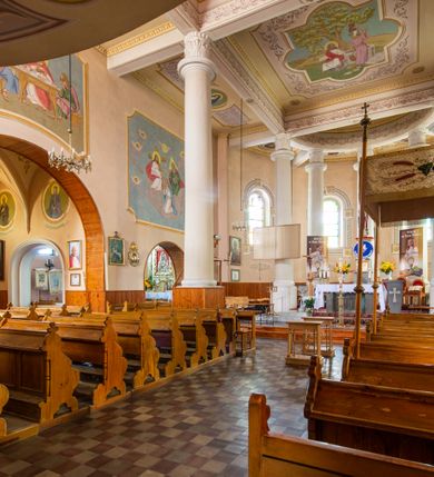 Zdjęcie nr 20: Kościół murowany z cegły na niskiej, kamiennej podmurówce, orientowany, jednonawowy ze zredukowanym transeptem oraz nieco niższym, zamkniętym półkoliście prezbiterium. Do północno-wschodniego narożnika nawy (przy prezbiterium) przylega założona na rzucie prostokąta, oszkarpowana zakrystia dostępna półkolistym portalem od strony północnej. Do południowo-wschodniego narożnika nawy dostawiona kaplica Matki Boskiej na rzucie prostokąta zamknięta od wschodu niewielką absydą. Ramiona transeptu zredukowane do roli prostokątnych kaplic. Do południowo-zachodniego i północno-zachodniego narożnika nawy dobudowane nowsze kruchty boczne założone na rzucie prostokąta dostępne portalami o półkolistym wykroju. Kruchta zachodnia na rzucie prostokąta dostępna nowym, prostokątnym wejściem. W ścianach północnej i południowej widoczne, zamurowane, starsze otwory wejściowe (od południa w miejsce portalu okrągłe okno). Dach nad nawą dwuspadowy z trzecią połacią zakrywającą ścianę szczytową; w części wschodniej wieloboczna wieżyczka na sygnaturkę z glorietą zwieńczoną krzyżem. Kruchty oraz kaplice boczne kryte dachami trójpołaciowymi, prezbiterium jednopołaciowym; nad zakrystią dach mansardowy z prostokątnym oknem w lukarnie. Pokrycia dachowe wykonane są z blachy (pierwotnie była to czerwona dachówka). W nawie i prezbiterium strop o konstrukcji żelbetowej wsparty na dziewięciu masywnych kolumnach ustawionych na wysokich cokołach; kaplice boczne sklepione krzyżowo, w zakrystii założony betonowy strop. Chór muzyczny murowany, wsparty na pierwszej od zachodu parze kolumn dźwigających strop. Fasada jednokondygnacyjna, trójosiowa z umieszczoną w osi centralnej prostopadłościenną kruchtą mieszczącą prostokątny otwór wejściowy (nowy). Okna w kształcie stojącego prostokąta o smukłych proporcjach, zamknięte półkoliście. Okno środkowe, umieszczone nieco wyżej, niższe od pozostałych. W ścianach zachodnich krucht bocznych po jednym niewielkim oknie o wykroju półkolistym. Trójkątna ściana szczytowa zasłonięta blaszanym dachem o przełamanej w dolnej części połaci, zwieńczona niewielkim, metalowym krzyżem. Elewacje boczne jednokondygnacyjne, o nieregularnym przebiegu osi. W elewacji południowej w pierwszej osi ceglany portal z nadświetlem o wykroju półkolistym, w drugiej okrągłe okno doświetlające kaplicę boczną, w kolejnych: półkolisty ceglany portal do zakrystii oraz okno o półkolistym wykroju z motywem biforium. W elewacji północnej w osi pierwszej i drugiej niewielkie półkoliście wykrojone okna, w osi trzeciej okrągłe okno doświetlające kaplicę, w osi czwartej natomiast ceglany portal  z nadświetlem o wykroju półkolistym. W prezbiterium cztery okna o wykroju półkolistym. W trzeciej osi, pomiędzy oknami, ujęta wielobocznymi filarami dźwigającymi, wydatny, profilowany gzyms tynkowana na biało nisza z figurą Matki Boskiej Fatimskiej umieszczonej pod baldachimem. Górną część murów nawy, prezbiterium, zakrystii, kaplic oraz obu krucht bocznych obiega profilowany gzyms okapowy. 