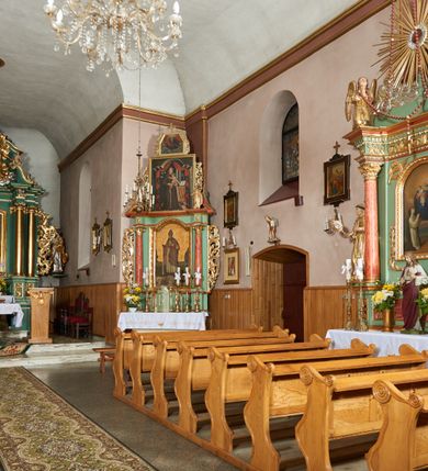 Zdjęcie nr 6: Kościół orientowany, murowany z kamienia i cegły, na planie prostokąta z szerszą nawą i węższym prezbiterium o zamknięciu wielobocznym, dobudowaną zakrystią, kruchtą od frontu i przedsionkiem od południa.  Od zachodu chór muzyczny z organami wsparty na dwóch kolumnach. Na ścianach iluzjonistyczne płyciny z fragmentami wici akantowej, glify we wnękach okiennych, na gzymsie ornament kostkowy, na stropie delikatna polichromia geometryczna z fragmentami wici akantowej. 
Nawa i prezbiterium przykryte stropem z głęboką fasetą imitującą sklepienie zwierciadlane, z oddzielającym je od partii ścian gzymsem. 
Otwory okienne w kształcie stojących prostokątów zakończonych półkoliście, różnej wielkości. Jedno okno w prezbiterium, po dwa z każdej strony nawy, dwa w kruchcie, dwa w fasadzie, a powyżej nich niewielki okulus. 
Główne wejście do kościoła od zachodu, przez kruchtę, kolejne od południa, przez przybudówkę, następne do zakrystii i do kotłowni.
Fasada została zakomponowana z dwóch części. Ściana kościoła jest zwieńczona trójkątnym szczytem ujętym niewysokimi murkami i zakończonym półokrągło, a przed jej lico wychodzi prostopadłościenna kruchta z małym, trójkątnym szczytem opracowanym podobnie jak szczyt fasady. 
Kościół ustawiony na cokole z kamienną okładziną. Elewacje zewnętrzne są gładkie, z podziałami lizenowo-ramowymi:  naroża podkreślone lizenami, kondygnacja oddzielona od partii dachu gzymsem podokapowym. 
Dachy dwuspadowe, kryte dachówką, na kalenicy nawy sześcioboczna wieżyczka na sygnaturkę z hełmem cebulastym krytym blachą. 