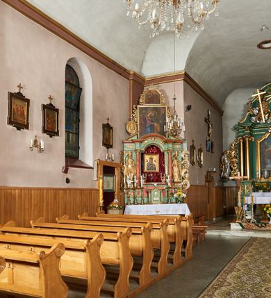 Zdjęcie nr 9: Kościół orientowany, murowany z kamienia i cegły, na planie prostokąta z szerszą nawą i węższym prezbiterium o zamknięciu wielobocznym, dobudowaną zakrystią, kruchtą od frontu i przedsionkiem od południa.  Od zachodu chór muzyczny z organami wsparty na dwóch kolumnach. Na ścianach iluzjonistyczne płyciny z fragmentami wici akantowej, glify we wnękach okiennych, na gzymsie ornament kostkowy, na stropie delikatna polichromia geometryczna z fragmentami wici akantowej. 
Nawa i prezbiterium przykryte stropem z głęboką fasetą imitującą sklepienie zwierciadlane, z oddzielającym je od partii ścian gzymsem. 
Otwory okienne w kształcie stojących prostokątów zakończonych półkoliście, różnej wielkości. Jedno okno w prezbiterium, po dwa z każdej strony nawy, dwa w kruchcie, dwa w fasadzie, a powyżej nich niewielki okulus. 
Główne wejście do kościoła od zachodu, przez kruchtę, kolejne od południa, przez przybudówkę, następne do zakrystii i do kotłowni.
Fasada została zakomponowana z dwóch części. Ściana kościoła jest zwieńczona trójkątnym szczytem ujętym niewysokimi murkami i zakończonym półokrągło, a przed jej lico wychodzi prostopadłościenna kruchta z małym, trójkątnym szczytem opracowanym podobnie jak szczyt fasady. 
Kościół ustawiony na cokole z kamienną okładziną. Elewacje zewnętrzne są gładkie, z podziałami lizenowo-ramowymi:  naroża podkreślone lizenami, kondygnacja oddzielona od partii dachu gzymsem podokapowym. 
Dachy dwuspadowe, kryte dachówką, na kalenicy nawy sześcioboczna wieżyczka na sygnaturkę z hełmem cebulastym krytym blachą. 