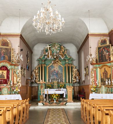 Zdjęcie nr 7: Kościół orientowany, murowany z kamienia i cegły, na planie prostokąta z szerszą nawą i węższym prezbiterium o zamknięciu wielobocznym, dobudowaną zakrystią, kruchtą od frontu i przedsionkiem od południa.  Od zachodu chór muzyczny z organami wsparty na dwóch kolumnach. Na ścianach iluzjonistyczne płyciny z fragmentami wici akantowej, glify we wnękach okiennych, na gzymsie ornament kostkowy, na stropie delikatna polichromia geometryczna z fragmentami wici akantowej. 
Nawa i prezbiterium przykryte stropem z głęboką fasetą imitującą sklepienie zwierciadlane, z oddzielającym je od partii ścian gzymsem. 
Otwory okienne w kształcie stojących prostokątów zakończonych półkoliście, różnej wielkości. Jedno okno w prezbiterium, po dwa z każdej strony nawy, dwa w kruchcie, dwa w fasadzie, a powyżej nich niewielki okulus. 
Główne wejście do kościoła od zachodu, przez kruchtę, kolejne od południa, przez przybudówkę, następne do zakrystii i do kotłowni.
Fasada została zakomponowana z dwóch części. Ściana kościoła jest zwieńczona trójkątnym szczytem ujętym niewysokimi murkami i zakończonym półokrągło, a przed jej lico wychodzi prostopadłościenna kruchta z małym, trójkątnym szczytem opracowanym podobnie jak szczyt fasady. 
Kościół ustawiony na cokole z kamienną okładziną. Elewacje zewnętrzne są gładkie, z podziałami lizenowo-ramowymi:  naroża podkreślone lizenami, kondygnacja oddzielona od partii dachu gzymsem podokapowym. 
Dachy dwuspadowe, kryte dachówką, na kalenicy nawy sześcioboczna wieżyczka na sygnaturkę z hełmem cebulastym krytym blachą. 