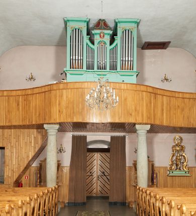 Zdjęcie nr 11: Kościół orientowany, murowany z kamienia i cegły, na planie prostokąta z szerszą nawą i węższym prezbiterium o zamknięciu wielobocznym, dobudowaną zakrystią, kruchtą od frontu i przedsionkiem od południa.  Od zachodu chór muzyczny z organami wsparty na dwóch kolumnach. Na ścianach iluzjonistyczne płyciny z fragmentami wici akantowej, glify we wnękach okiennych, na gzymsie ornament kostkowy, na stropie delikatna polichromia geometryczna z fragmentami wici akantowej. 
Nawa i prezbiterium przykryte stropem z głęboką fasetą imitującą sklepienie zwierciadlane, z oddzielającym je od partii ścian gzymsem. 
Otwory okienne w kształcie stojących prostokątów zakończonych półkoliście, różnej wielkości. Jedno okno w prezbiterium, po dwa z każdej strony nawy, dwa w kruchcie, dwa w fasadzie, a powyżej nich niewielki okulus. 
Główne wejście do kościoła od zachodu, przez kruchtę, kolejne od południa, przez przybudówkę, następne do zakrystii i do kotłowni.
Fasada została zakomponowana z dwóch części. Ściana kościoła jest zwieńczona trójkątnym szczytem ujętym niewysokimi murkami i zakończonym półokrągło, a przed jej lico wychodzi prostopadłościenna kruchta z małym, trójkątnym szczytem opracowanym podobnie jak szczyt fasady. 
Kościół ustawiony na cokole z kamienną okładziną. Elewacje zewnętrzne są gładkie, z podziałami lizenowo-ramowymi:  naroża podkreślone lizenami, kondygnacja oddzielona od partii dachu gzymsem podokapowym. 
Dachy dwuspadowe, kryte dachówką, na kalenicy nawy sześcioboczna wieżyczka na sygnaturkę z hełmem cebulastym krytym blachą. 