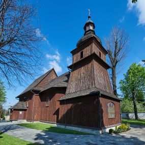 Zdjęcie nr 1: Kościół orientowany, drewniany, na podmurówce z kamienia łupanego, konstrukcji zrębowej, jednonawowy, szalowany, z wieżą konstrukcji słupowej usytuowaną od strony prezbiterium, z zakrystią w przyziemiu. Nawa prostokątna, szersza od prezbiterium, z kruchtami od zachodu, południa i północy. Prezbiterium zamknięte trójbocznie. Wieża od wschodu, na planie kwadratu, o konstrukcji ze słupów pochyłych, na zewnątrz trzy kondygnacje przedzielone obiegającymi daszkami. Dolna i górna izbica o ścianach pionowych, środkowa o ścianach pochyłych; wieża zwieńczona hełmem baniastym z latarnią. Kościół przykrywa dach siodłowy, na kruchtach trójspadowy, kryty cementówką. Pod wydatnymi okapami dachów biegnie gzyms o profilu ćwierćkoliście wklęsłym z wałkiem. Więźba dachowa nad prezbiterium jest krokwiowa, a nad nawą płatwiowa. Wewnątrz znajdują się stropy z fasetami, pod którymi umieszczony jest profilowany gzyms. Arkada tęczowa o łuku spłaszczonym. Chór muzyczny wsparty jest na dwóch filarach z wybrzuszoną balustradą. Wnętrze polichromowane, ściany w kruchtach oszalowane. Do kościoła prowadzą cztery wejścia: główne od zachodu, dwa boczne od południa i północy oraz przez zakrystię od wieży, od strony północno-zachodniej. W prezbiterium znajdują się dwa okna: po stronie południowej i północnej; a w nawie dwa po stronie południowej i północnej, natomiast w wieży cztery okna prostokątne, w latarni osiem okien zamkniętych dwoma nałęczami. Kościół otoczony jest murkiem ze stacjami drogi krzyżowej i dwiema bramkami z lat 1863 i 1864.