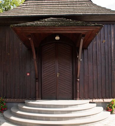 Zdjęcie nr 10: Kościół orientowany, drewniany, na podmurówce z kamienia łupanego, konstrukcji zrębowej, jednonawowy, szalowany, z wieżą konstrukcji słupowej usytuowaną od strony prezbiterium, z zakrystią w przyziemiu. Nawa prostokątna, szersza od prezbiterium, z kruchtami od zachodu, południa i północy. Prezbiterium zamknięte trójbocznie. Wieża od wschodu, na planie kwadratu, o konstrukcji ze słupów pochyłych, na zewnątrz trzy kondygnacje przedzielone obiegającymi daszkami. Dolna i górna izbica o ścianach pionowych, środkowa o ścianach pochyłych; wieża zwieńczona hełmem baniastym z latarnią. Kościół przykrywa dach siodłowy, na kruchtach trójspadowy, kryty cementówką. Pod wydatnymi okapami dachów biegnie gzyms o profilu ćwierćkoliście wklęsłym z wałkiem. Więźba dachowa nad prezbiterium jest krokwiowa, a nad nawą płatwiowa. Wewnątrz znajdują się stropy z fasetami, pod którymi umieszczony jest profilowany gzyms. Arkada tęczowa o łuku spłaszczonym. Chór muzyczny wsparty jest na dwóch filarach z wybrzuszoną balustradą. Wnętrze polichromowane, ściany w kruchtach oszalowane. Do kościoła prowadzą cztery wejścia: główne od zachodu, dwa boczne od południa i północy oraz przez zakrystię od wieży, od strony północno-zachodniej. W prezbiterium znajdują się dwa okna: po stronie południowej i północnej; a w nawie dwa po stronie południowej i północnej, natomiast w wieży cztery okna prostokątne, w latarni osiem okien zamkniętych dwoma nałęczami. Kościół otoczony jest murkiem ze stacjami drogi krzyżowej i dwiema bramkami z lat 1863 i 1864.