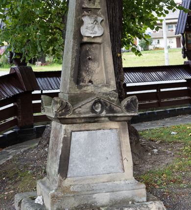 Zdjęcie nr 19: Kościół Przemienienia Pańskiego w Radoczy usytuowany jest w centrum wsi na zachód od głównej drogi prowadzącej z Wadowic do Zatora. Teren przykościelny jest usytuowany na niewielkim wzniesieniu, otoczony drewnianym płotem. Główne wejście na plac przykościelny prowadzi przez bramę od strony zachodniej.

Kościół jest orientowany, drewniany o konstrukcji zrębowej z wieżą na słup, jednonawowy z krótszym prezbiterium zamkniętym trójbocznie. Przy prezbiterium od wschodu nowsza zakrystia murowana, od północy kaplica i składzik, przy nawie od południa kruchta. Wnętrze nakryte pułapem, w nawie z zaskrzynieniami. Ściana arkady tęczowej o wykroju prostokątnym ze ściętymi narożami. Do kościoła prowadzi główne wejście w wieży od strony północnej. Wnętrze świątyni oświetlają prostokątne okna od strony południowej. Dach o jednej kalenicy, kryty blachą, na środku drewniana sygnaturka, nakryta kopułką z latarnią.  Od zachodu wieża w dolnej kondygnacji na planie prostokąta, ujęta po bokach daszkami; druga kondygnacja o ścianach pochyłych, pokryta gontem; trzecia kondygnacja prześwietlona prostokątnymi otworami okiennymi; wieża zakończona iglicą. Ściany na zewnątrz pokryte szalunkiem pionowym.
