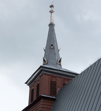 Zdjęcie nr 39: Kościół Przemienienia Pańskiego w Radoczy usytuowany jest w centrum wsi na zachód od głównej drogi prowadzącej z Wadowic do Zatora. Teren przykościelny jest usytuowany na niewielkim wzniesieniu, otoczony drewnianym płotem. Główne wejście na plac przykościelny prowadzi przez bramę od strony zachodniej.

Kościół jest orientowany, drewniany o konstrukcji zrębowej z wieżą na słup, jednonawowy z krótszym prezbiterium zamkniętym trójbocznie. Przy prezbiterium od wschodu nowsza zakrystia murowana, od północy kaplica i składzik, przy nawie od południa kruchta. Wnętrze nakryte pułapem, w nawie z zaskrzynieniami. Ściana arkady tęczowej o wykroju prostokątnym ze ściętymi narożami. Do kościoła prowadzi główne wejście w wieży od strony północnej. Wnętrze świątyni oświetlają prostokątne okna od strony południowej. Dach o jednej kalenicy, kryty blachą, na środku drewniana sygnaturka, nakryta kopułką z latarnią.  Od zachodu wieża w dolnej kondygnacji na planie prostokąta, ujęta po bokach daszkami; druga kondygnacja o ścianach pochyłych, pokryta gontem; trzecia kondygnacja prześwietlona prostokątnymi otworami okiennymi; wieża zakończona iglicą. Ściany na zewnątrz pokryte szalunkiem pionowym.
