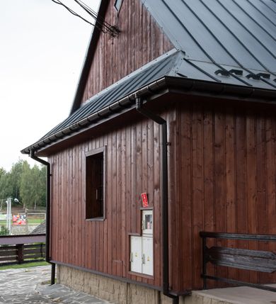 Zdjęcie nr 46: Kościół Przemienienia Pańskiego w Radoczy usytuowany jest w centrum wsi na zachód od głównej drogi prowadzącej z Wadowic do Zatora. Teren przykościelny jest usytuowany na niewielkim wzniesieniu, otoczony drewnianym płotem. Główne wejście na plac przykościelny prowadzi przez bramę od strony zachodniej.

Kościół jest orientowany, drewniany o konstrukcji zrębowej z wieżą na słup, jednonawowy z krótszym prezbiterium zamkniętym trójbocznie. Przy prezbiterium od wschodu nowsza zakrystia murowana, od północy kaplica i składzik, przy nawie od południa kruchta. Wnętrze nakryte pułapem, w nawie z zaskrzynieniami. Ściana arkady tęczowej o wykroju prostokątnym ze ściętymi narożami. Do kościoła prowadzi główne wejście w wieży od strony północnej. Wnętrze świątyni oświetlają prostokątne okna od strony południowej. Dach o jednej kalenicy, kryty blachą, na środku drewniana sygnaturka, nakryta kopułką z latarnią.  Od zachodu wieża w dolnej kondygnacji na planie prostokąta, ujęta po bokach daszkami; druga kondygnacja o ścianach pochyłych, pokryta gontem; trzecia kondygnacja prześwietlona prostokątnymi otworami okiennymi; wieża zakończona iglicą. Ściany na zewnątrz pokryte szalunkiem pionowym.
