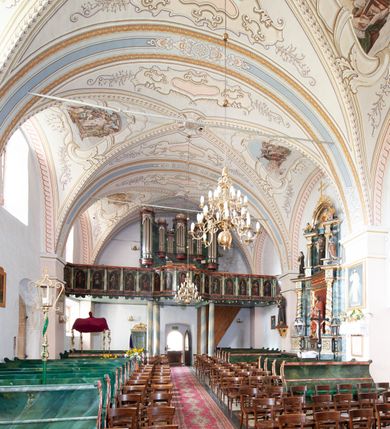 Zdjęcie nr 17: Kościół orientowany, murowany z kamienia, jednonawowy, z prostokątną, trójprzęsłową nawą oraz węższym dwuprzęsłowym prezbiterium zamkniętym prosto, z prostokątną zakrystią przy północnej ścianie. Od zachodu wieża na planie kwadratu, do północnej ściany nawy dobudowana kaplica na rzucie kwadratu o ściętych narożach, do południowej niewielka kruchta na planie kwadratu. Prezbiterium nakryte sklepieniem krzyżowo-żebrowym z dwoma zwornikami. 
Nawa sklepiona krzyżowo, przęsła wydzielone arkadami wspartymi na półfilarach. Otwór tęczowy w formie stojącego prostokąta zamkniętego łukiem półkolistym. W zachodniej części nawy parapet chóru muzycznego, z wybrzuszoną środkową częścią balustrady, wsparty na czterech kolumnach. 
Fasada wieżowa, z wejściem na osi. Wieża smukła, bez podziałów architektonicznych, zakończona profilowanym gzymsem, wyłamującym się na każdej ścianie na kształt łuku odcinkowego. W najwyższej partii ścian, z trzech stron, okna w formie stojącego prostokąta zamkniętego półkoliście. Wieża zwieńczona hełmem baniastym z latarnią, pokrytym gontem. 
Kościół opięty szkarpami dwuuskokowymi, nakrytymi daszkami gontowymi. W elewacji południowej pomiędzy szkarpami pięć wąskich okien w formie stojącego prostokąta zamkniętego łukiem półkolistym. Na wschodniej dobudowany ogrojec w formie masywnej arkady, zamkniętej dwuspadowym daszkiem z ołtarzem i krucyfiksem. Nawa i prezbiterium nakryte osobnymi dachami dwuspadowymi, gontowymi. Nad prezbiterium drewniana wieżyczka na sygnaturkę, z latarnią, zwieńczona hełmem baniastym. Kaplica przykryta dachem gontowych, trójspadowym, kruchta zaś pulpitowym. 
Kościół otoczony niskim murem kamiennym, nakrytym daszkiem gontowym. Od wschodu dwie bramy flankowane filarami z wazonami. 

