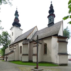 Zdjęcie nr 1: Kościół orientowany, murowany z kamienia, jednonawowy, z prostokątną, trójprzęsłową nawą oraz węższym dwuprzęsłowym prezbiterium zamkniętym prosto, z prostokątną zakrystią przy północnej ścianie. Od zachodu wieża na planie kwadratu, do północnej ściany nawy dobudowana kaplica na rzucie kwadratu o ściętych narożach, do południowej niewielka kruchta na planie kwadratu. Prezbiterium nakryte sklepieniem krzyżowo-żebrowym z dwoma zwornikami. 
Nawa sklepiona krzyżowo, przęsła wydzielone arkadami wspartymi na półfilarach. Otwór tęczowy w formie stojącego prostokąta zamkniętego łukiem półkolistym. W zachodniej części nawy parapet chóru muzycznego, z wybrzuszoną środkową częścią balustrady, wsparty na czterech kolumnach. 
Fasada wieżowa, z wejściem na osi. Wieża smukła, bez podziałów architektonicznych, zakończona profilowanym gzymsem, wyłamującym się na każdej ścianie na kształt łuku odcinkowego. W najwyższej partii ścian, z trzech stron, okna w formie stojącego prostokąta zamkniętego półkoliście. Wieża zwieńczona hełmem baniastym z latarnią, pokrytym gontem. 
Kościół opięty szkarpami dwuuskokowymi, nakrytymi daszkami gontowymi. W elewacji południowej pomiędzy szkarpami pięć wąskich okien w formie stojącego prostokąta zamkniętego łukiem półkolistym. Na wschodniej dobudowany ogrojec w formie masywnej arkady, zamkniętej dwuspadowym daszkiem z ołtarzem i krucyfiksem. Nawa i prezbiterium nakryte osobnymi dachami dwuspadowymi, gontowymi. Nad prezbiterium drewniana wieżyczka na sygnaturkę, z latarnią, zwieńczona hełmem baniastym. Kaplica przykryta dachem gontowych, trójspadowym, kruchta zaś pulpitowym. 
Kościół otoczony niskim murem kamiennym, nakrytym daszkiem gontowym. Od wschodu dwie bramy flankowane filarami z wazonami. 

