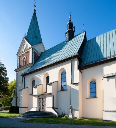 Zdjęcie nr 13: Kościół orientowany, jednonawowy, z krótkim zakończonym wielobocznie prezbiterium, przy którym od północy zakrystia z nowszym przedsionkiem; przy nawie od północy prostokątna kaplica Różańcowa (1712 r.), od zachodu wieża na rzucie kwadratu, od południa drewniana kruchta. Wewnątrz stropy. Arkada tęczy szeroka półkolista. Zewnątrz mury opięte przyporami, tynkowane. Dachy dwuspadowe i pulpitowe. Na kalenicy dachu nawy wieżyczka na sygnaturkę z datą 1878. Okna prostokątne zamknięte półkoliście. Dwa portale kamienne prostokątne. Wieża dołem gotycka, nadbudowana w stylu pseudoromańskim; trójkondygnacyjna, dołem z narożnikami artykułowanymi boniowaniem, narożniki górnej kondygnacji ujęte lizenami połączonymi fryzem arkadkowym. Elewacje wieży zwieńczone trójkątnymi szczytami i ostrosłupowym hełmem krytym blachą.