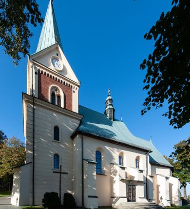 Zdjęcie nr 1: Kościół orientowany, jednonawowy, z krótkim zakończonym wielobocznie prezbiterium, przy którym od północy zakrystia z nowszym przedsionkiem; przy nawie od północy prostokątna kaplica Różańcowa (1712 r.), od zachodu wieża na rzucie kwadratu, od południa drewniana kruchta. Wewnątrz stropy. Arkada tęczy szeroka półkolista. Zewnątrz mury opięte przyporami, tynkowane. Dachy dwuspadowe i pulpitowe. Na kalenicy dachu nawy wieżyczka na sygnaturkę z datą 1878. Okna prostokątne zamknięte półkoliście. Dwa portale kamienne prostokątne. Wieża dołem gotycka, nadbudowana w stylu pseudoromańskim; trójkondygnacyjna, dołem z narożnikami artykułowanymi boniowaniem, narożniki górnej kondygnacji ujęte lizenami połączonymi fryzem arkadkowym. Elewacje wieży zwieńczone trójkątnymi szczytami i ostrosłupowym hełmem krytym blachą.