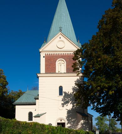 Zdjęcie nr 23: Kościół orientowany, jednonawowy, z krótkim zakończonym wielobocznie prezbiterium, przy którym od północy zakrystia z nowszym przedsionkiem; przy nawie od północy prostokątna kaplica Różańcowa (1712 r.), od zachodu wieża na rzucie kwadratu, od południa drewniana kruchta. Wewnątrz stropy. Arkada tęczy szeroka półkolista. Zewnątrz mury opięte przyporami, tynkowane. Dachy dwuspadowe i pulpitowe. Na kalenicy dachu nawy wieżyczka na sygnaturkę z datą 1878. Okna prostokątne zamknięte półkoliście. Dwa portale kamienne prostokątne. Wieża dołem gotycka, nadbudowana w stylu pseudoromańskim; trójkondygnacyjna, dołem z narożnikami artykułowanymi boniowaniem, narożniki górnej kondygnacji ujęte lizenami połączonymi fryzem arkadkowym. Elewacje wieży zwieńczone trójkątnymi szczytami i ostrosłupowym hełmem krytym blachą.