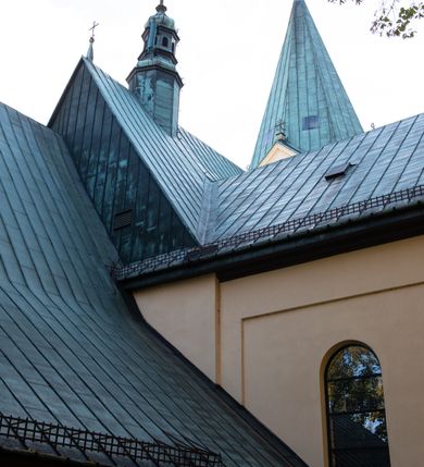 Zdjęcie nr 4: Kościół orientowany, jednonawowy, z krótkim zakończonym wielobocznie prezbiterium, przy którym od północy zakrystia z nowszym przedsionkiem; przy nawie od północy prostokątna kaplica Różańcowa (1712 r.), od zachodu wieża na rzucie kwadratu, od południa drewniana kruchta. Wewnątrz stropy. Arkada tęczy szeroka półkolista. Zewnątrz mury opięte przyporami, tynkowane. Dachy dwuspadowe i pulpitowe. Na kalenicy dachu nawy wieżyczka na sygnaturkę z datą 1878. Okna prostokątne zamknięte półkoliście. Dwa portale kamienne prostokątne. Wieża dołem gotycka, nadbudowana w stylu pseudoromańskim; trójkondygnacyjna, dołem z narożnikami artykułowanymi boniowaniem, narożniki górnej kondygnacji ujęte lizenami połączonymi fryzem arkadkowym. Elewacje wieży zwieńczone trójkątnymi szczytami i ostrosłupowym hełmem krytym blachą.