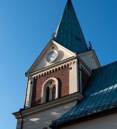 Zdjęcie nr 24: Kościół orientowany, jednonawowy, z krótkim zakończonym wielobocznie prezbiterium, przy którym od północy zakrystia z nowszym przedsionkiem; przy nawie od północy prostokątna kaplica Różańcowa (1712 r.), od zachodu wieża na rzucie kwadratu, od południa drewniana kruchta. Wewnątrz stropy. Arkada tęczy szeroka półkolista. Zewnątrz mury opięte przyporami, tynkowane. Dachy dwuspadowe i pulpitowe. Na kalenicy dachu nawy wieżyczka na sygnaturkę z datą 1878. Okna prostokątne zamknięte półkoliście. Dwa portale kamienne prostokątne. Wieża dołem gotycka, nadbudowana w stylu pseudoromańskim; trójkondygnacyjna, dołem z narożnikami artykułowanymi boniowaniem, narożniki górnej kondygnacji ujęte lizenami połączonymi fryzem arkadkowym. Elewacje wieży zwieńczone trójkątnymi szczytami i ostrosłupowym hełmem krytym blachą.