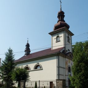 Zdjęcie nr 1: Kościół murowany, składa się z nawy i zwróconego na południe prezbiterium, do którego przylega zakrystia, nad którą znajduje się skarbiec; od północy wieża. Prezbiterium jest węższe od nawy, o zaokrąglonych narożach, oddzielone od prostokątnej nawy łukiem tęczowym. Ściany kościoła gładkie, przeprute półkolistymi oknami – dwoma w prezbiterium, sześcioma w nawie. Od zachodu chór wsparty na dwóch kolumnach, z balustradą wyłamaną na środku, dekorowaną u spodu lambrekinem. Ściany kościoła gładkie, w dolnej partii osłonięte drewnianą boazerią, z wnęką na chrzcielnicę po lewej i drugą na drzwi z prawej strony. Wnętrze przekrywają stropy – zwierciadlany w prezbiterium i płaski  z fasetami w nawie. Na nich oraz w górnej partii ścian polichromia. Nad prezbiterium wizerunek zmartwychwstałego Chrystusa, nad nawą zakomponowana w kole scena adoracji Najświętszej Marii Panny przez apostołów, poniżej, na ścianach medaliony z postaciami ważnych osobistości, świętych i aniołów. Główne drzwi od północy, boczne od zachodu. 
Kościół posadowiony na cokole. Elewacja frontowa ze zdwojonym ryzalitem, którego środek odpowiada szerokości wieży; podziały poziome przeprowadzone przy pomocy gzymsów. Na osi wejście i  okno, oba w boniowanym obramieniu. Okno ujmuje polichromowana scena Zwiastowania. Ryzalit wieńczy trójkątny fronton. Cofnięty ryzalit w dolnej partii boniowany, wyżej gładki, zwieńczony ćwierćkolistymi fragmentami przerwanego przyczółka. Boki elewacji frontowej gładkie, zwieńczone frontonem przerwanym na masyw czworobocznej wieży przeprutej z każdej strony oknem w kształcie stojącego prostokąta zamkniętego łukiem pełnym. Elewacje boczne gładkie, przeprute półkolistymi oknami. Od wschodu poniżej okien szare płyciny, od południa, w kapliczkowej oprawie grupa Ukrzyżowania. Dach nad nawą dwuspadowy, nad prezbiterium trójspadowy, dach wieńczy baniasty hełm z latarnią zakończony krzyżem, na kalenicy barokowa wieżyczka na sygnaturkę. 
