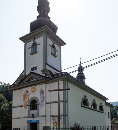 Zdjęcie nr 7: Kościół murowany, składa się z nawy i zwróconego na południe prezbiterium, do którego przylega zakrystia, nad którą znajduje się skarbiec; od północy wieża. Prezbiterium jest węższe od nawy, o zaokrąglonych narożach, oddzielone od prostokątnej nawy łukiem tęczowym. Ściany kościoła gładkie, przeprute półkolistymi oknami – dwoma w prezbiterium, sześcioma w nawie. Od zachodu chór wsparty na dwóch kolumnach, z balustradą wyłamaną na środku, dekorowaną u spodu lambrekinem. Ściany kościoła gładkie, w dolnej partii osłonięte drewnianą boazerią, z wnęką na chrzcielnicę po lewej i drugą na drzwi z prawej strony. Wnętrze przekrywają stropy – zwierciadlany w prezbiterium i płaski  z fasetami w nawie. Na nich oraz w górnej partii ścian polichromia. Nad prezbiterium wizerunek zmartwychwstałego Chrystusa, nad nawą zakomponowana w kole scena adoracji Najświętszej Marii Panny przez apostołów, poniżej, na ścianach medaliony z postaciami ważnych osobistości, świętych i aniołów. Główne drzwi od północy, boczne od zachodu. 
Kościół posadowiony na cokole. Elewacja frontowa ze zdwojonym ryzalitem, którego środek odpowiada szerokości wieży; podziały poziome przeprowadzone przy pomocy gzymsów. Na osi wejście i  okno, oba w boniowanym obramieniu. Okno ujmuje polichromowana scena Zwiastowania. Ryzalit wieńczy trójkątny fronton. Cofnięty ryzalit w dolnej partii boniowany, wyżej gładki, zwieńczony ćwierćkolistymi fragmentami przerwanego przyczółka. Boki elewacji frontowej gładkie, zwieńczone frontonem przerwanym na masyw czworobocznej wieży przeprutej z każdej strony oknem w kształcie stojącego prostokąta zamkniętego łukiem pełnym. Elewacje boczne gładkie, przeprute półkolistymi oknami. Od wschodu poniżej okien szare płyciny, od południa, w kapliczkowej oprawie grupa Ukrzyżowania. Dach nad nawą dwuspadowy, nad prezbiterium trójspadowy, dach wieńczy baniasty hełm z latarnią zakończony krzyżem, na kalenicy barokowa wieżyczka na sygnaturkę. 
