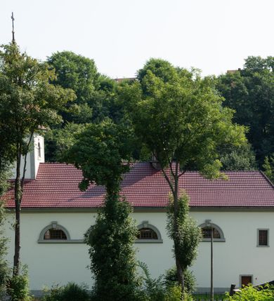 Zdjęcie nr 3: Kościół murowany, składa się z nawy i zwróconego na południe prezbiterium, do którego przylega zakrystia, nad którą znajduje się skarbiec; od północy wieża. Prezbiterium jest węższe od nawy, o zaokrąglonych narożach, oddzielone od prostokątnej nawy łukiem tęczowym. Ściany kościoła gładkie, przeprute półkolistymi oknami – dwoma w prezbiterium, sześcioma w nawie. Od zachodu chór wsparty na dwóch kolumnach, z balustradą wyłamaną na środku, dekorowaną u spodu lambrekinem. Ściany kościoła gładkie, w dolnej partii osłonięte drewnianą boazerią, z wnęką na chrzcielnicę po lewej i drugą na drzwi z prawej strony. Wnętrze przekrywają stropy – zwierciadlany w prezbiterium i płaski  z fasetami w nawie. Na nich oraz w górnej partii ścian polichromia. Nad prezbiterium wizerunek zmartwychwstałego Chrystusa, nad nawą zakomponowana w kole scena adoracji Najświętszej Marii Panny przez apostołów, poniżej, na ścianach medaliony z postaciami ważnych osobistości, świętych i aniołów. Główne drzwi od północy, boczne od zachodu. 
Kościół posadowiony na cokole. Elewacja frontowa ze zdwojonym ryzalitem, którego środek odpowiada szerokości wieży; podziały poziome przeprowadzone przy pomocy gzymsów. Na osi wejście i  okno, oba w boniowanym obramieniu. Okno ujmuje polichromowana scena Zwiastowania. Ryzalit wieńczy trójkątny fronton. Cofnięty ryzalit w dolnej partii boniowany, wyżej gładki, zwieńczony ćwierćkolistymi fragmentami przerwanego przyczółka. Boki elewacji frontowej gładkie, zwieńczone frontonem przerwanym na masyw czworobocznej wieży przeprutej z każdej strony oknem w kształcie stojącego prostokąta zamkniętego łukiem pełnym. Elewacje boczne gładkie, przeprute półkolistymi oknami. Od wschodu poniżej okien szare płyciny, od południa, w kapliczkowej oprawie grupa Ukrzyżowania. Dach nad nawą dwuspadowy, nad prezbiterium trójspadowy, dach wieńczy baniasty hełm z latarnią zakończony krzyżem, na kalenicy barokowa wieżyczka na sygnaturkę. 
